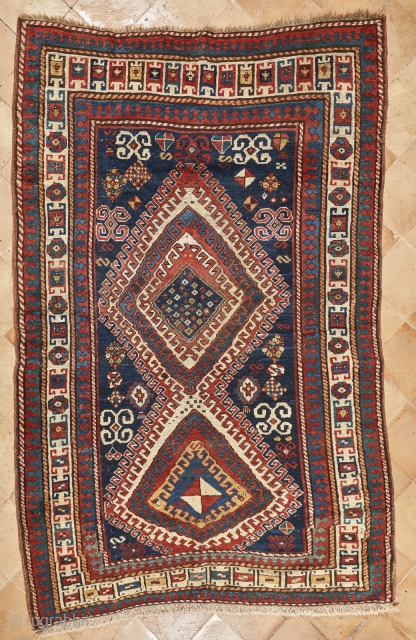 Beautiful, antique, tribal Kazak from Moghan area measuring 236x114cm with outstanding colours. On a blue ground there are two multi-hooked and multi colour medallions containing archetypic symbols of fertility and good luck.  ...