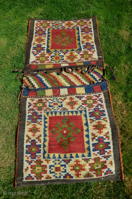 NW Persian flat woven khorjin. 57" X 25". Early 20th C.  Wool. Dovetailed tapestry. Bright stable cheerful colors. Plain woven back in natural undyed black wool. Lovingly kept in almost perfect  ...