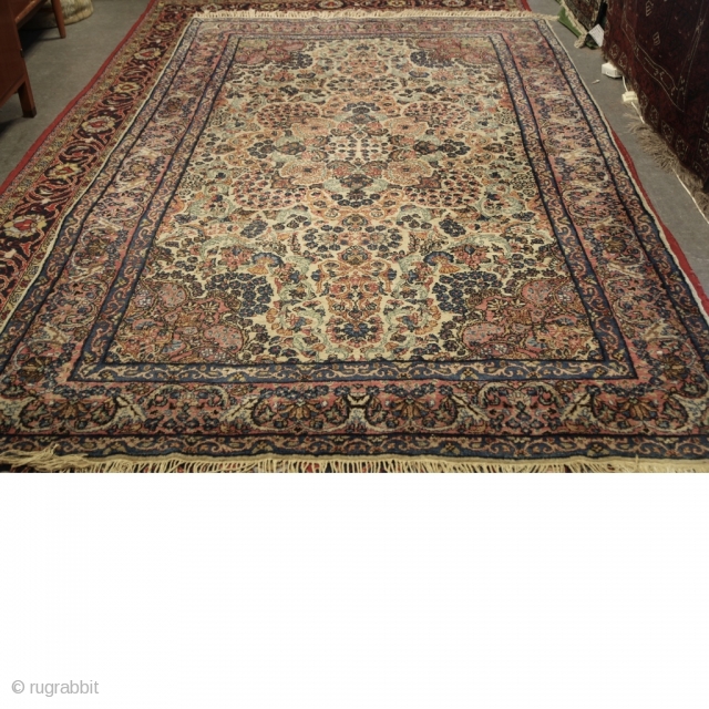 Antique Kirman Carpet
Size: 290cm x 178cm
Handwoven Antique Kirman Carpet, delicate blossoming medallion of flowers heads and sprays on a white ivory field. Pink corner spandrels encased in a delicate pink and blue  ...