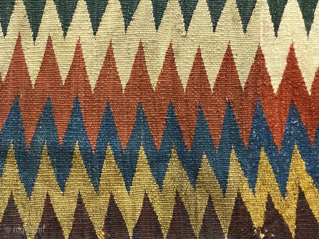 Shasavan Kilim Bagface -zig-zags-, ca.1870; 1’8” x 2’0”/ 51 x 62 cm. rows of zig-zag stripes in rust red, indigo, green, ivory, teal, goldenrod, and aubergine. Slight traces of fold lines.
  