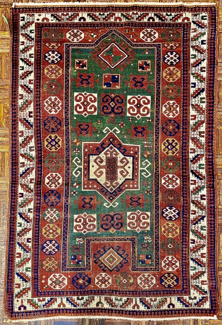 Karagashli Caucasian Prayer Rug; ca 1875;  4’2” x 6’3” / 127 x 190 cm.
Rich emerald green reentrant field with a concentric 8-sided medallion arrangement 
and symmetrical pairs of hooked squares in  ...