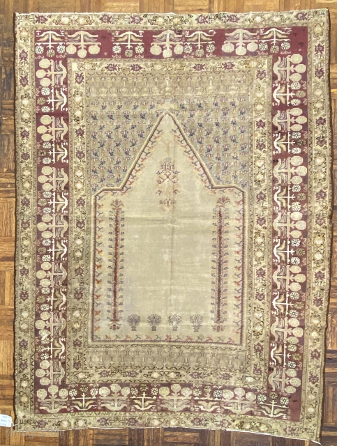 Turkish Panderma prayer rug, ca. 1850;  4ft. x 6ft. / 140 x 186 cm.

Pale-olive, multi-faceted mihrab, with a floral “mosque lamp”, two floral columns,
and four flowering shrubs; at the spandrels, a  ...