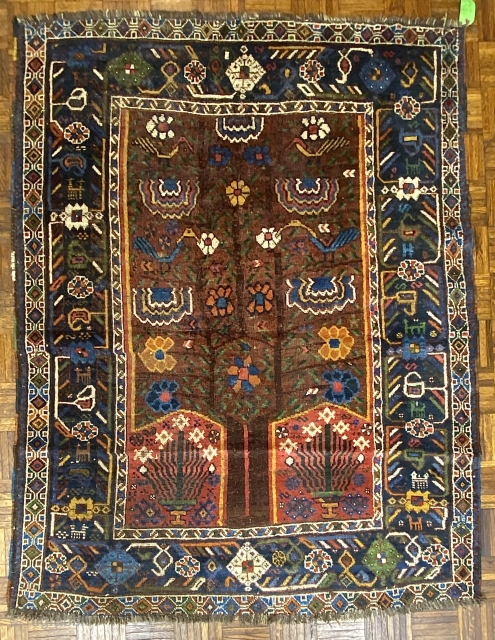 S.W. Per-zian  rug, 4’10” x 6’4” / 147 x 193 cm.

Mahogany brown field adorned with a flowering tree with whimsical 

birds and generously proportioned blossoms. Two reserves in red, to 

the  ...