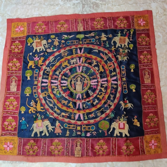 Mochi Embroidery of Jain Samavasarana.

In Jainism, Samavasarana ("Refuge for all") is the divine preaching hall of a Tirthankara represented here by Lord Mahavir.

Surrounding him in concentric circles are heavenly beings, ascetics, nuns,  ...