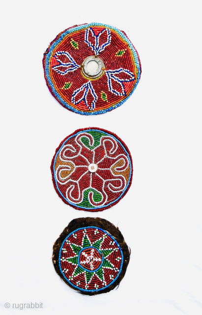 A set of 3 antique pieces from northern Afghanistan, decorated with glass beads on cotton and felt fabric. One features a shell button at the center, and another has a round metal  ...