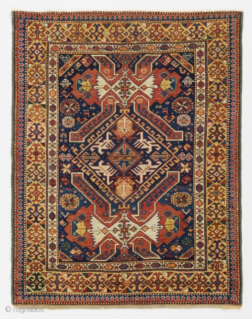 a handsome Kuba rug from North East Caucasus with shield, arms and dragons on a beautiful indigo blue ground framed by a rare yellow border. Very good condition with full pile and  ...