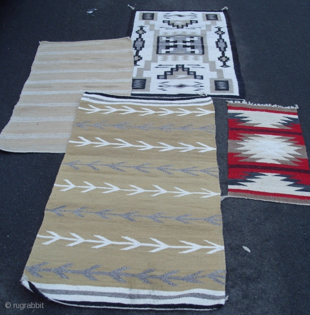 Four American Indian Rugs from a house clearance; pictorial storm pattern rug, a Gallup throw with cotton warps (the red one),one with arrows is a Chinle blanket/rug, other is a saddle blanket  ...