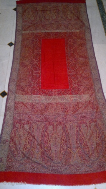A 19TH CENTUARY WOVEN KASHMIR LONG SHAWL FROM INDIA. ITS A BEAUTIFUL SHAWL WITH DEEP RED CENTER. THE BEAUTIFUL BOTEH DESIGNS ON EITHER SIDES ARE VERY ELEGENT WITH LEAVES AND STEM RIBBONS  ...