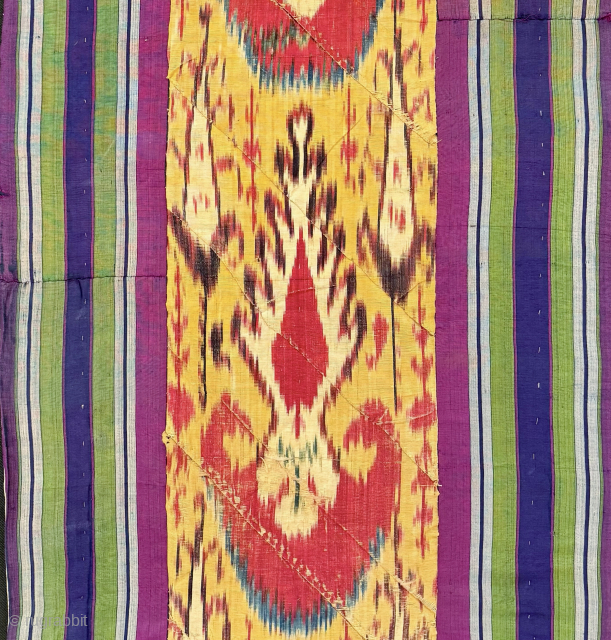 An outstanding antique silk warp / cotton weft Uzbek Adras early Ikat fragment hanging from Bukhara. All silk warp and cotton weft Adras Ikat. The central part, with a predominantly yellow ground,  ...