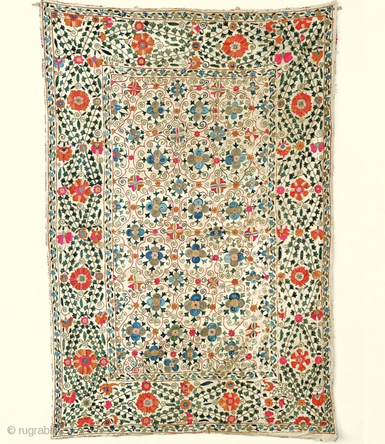 A majestic antique Uzbek silk suzani from 19th century Bukhara. This rare example boasts a magnificent and very elegant design. The lattice field contrasts beautifully with the intricately drawn free flowing floral  ...