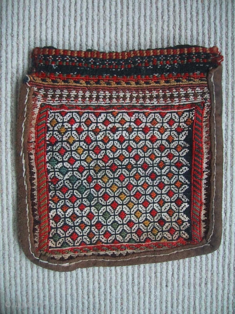 A charming small Qashqai chanteh, late 19th century. During its working life the bag has been reinforced with a rawhide strip around the edges. The velcro strip across the top of the  ...