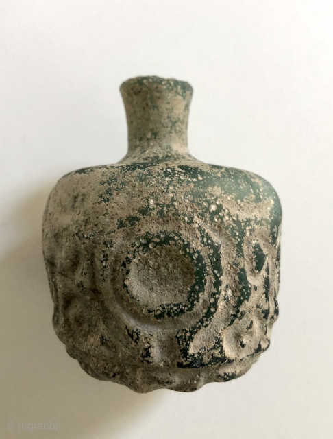 Jade green, thick walled Sassanian glass bottle.  Ancient Near East/Central Asia, Sassanid Empire.  Probably 5th century A.D.  Size: 3.25 x 2.50 inches. Deeply cut faceted design.  Typical pearlescent  ...