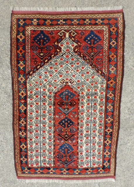 19th century Beshir prayer rug with a white ground mihrab that features clusters of stylized pomegranates. These prayer rugs are found in several different variants or groups as delineated by Ralph Kaffel  ...