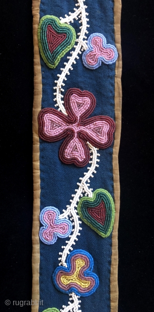 19th century Great Lakes bandolier bag strap.  Possibly Ojibwe tribe. Nine different colors of seed beads decorate this strap. The beads are sewn to a dark blue woolen trade cloth background  ...