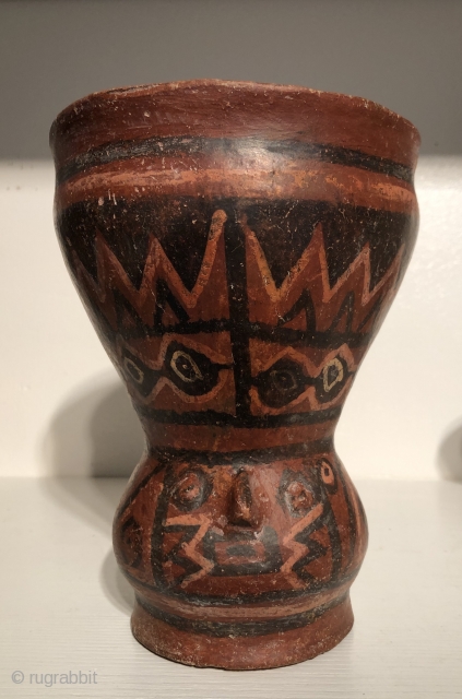 Ancient polychrome ceramic drinking vessel with modeled human head depiction.  Lake Titicaca Basin. A.D. 800 - 1100.  This red-ware vessel is decorated with molded a human face and has a  ...