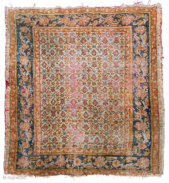 A small angora Oushak carpet, ivory field with allover floral and foliate design, blue main border with double guard bands, late 19th.century, areas of wear plus damages, 195 x 150cm.   