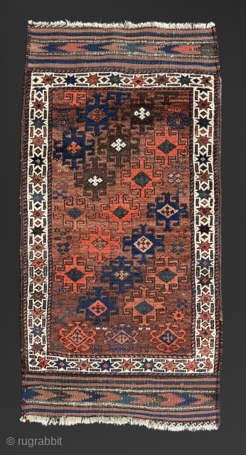 Antique Baluch. Saturated color in a wide palette on a ground of burnt-umber, largely undyed wool. In high pile with the exception of some slightly corroded browns. The gloss of ...
