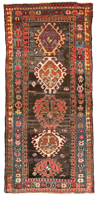 "Mystery" Caucasian long rug, 41 x 96 inches / 104 x 244 cm. Five differently conceived hooked diamond medallions on a black field. I suspect it may have originated from the NorthEast  ...