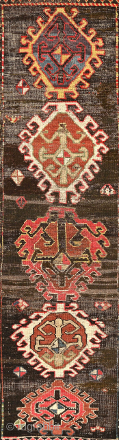 Dramatic and exceptional Caucasus long rug, 5 diversely drawn Hooked Diamonds on Dark Brown-Black Field, 104 x 244 cm  (3'5" x 8'). Coarse, irregular weave, deep saturated reds, greens, blues, yellows  ...