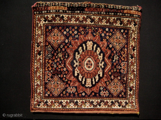 Qashqa'i bag with uncommon sun/lotus motif. Good condition and colours; unattached at sides, but with back and fastening cord. Probably early 20th century; 22" x 22".       