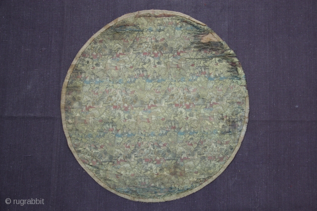 A beautiful Mughal-period Shield Cover richly decorated with war scenes all over, featuring soldiers fighting on foot and on horseback and courtiers. Thin golden metallic thread has been used all over.  