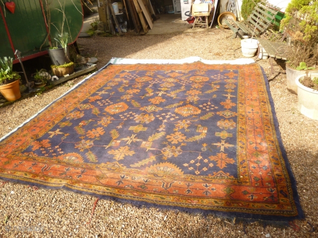 Old Oushak carpet. Over 95% full pile. Age-related wear, minor damage consistent with a roughly hundred year old antique. A couple of ragged areas at the outer border. There are a few,  ...