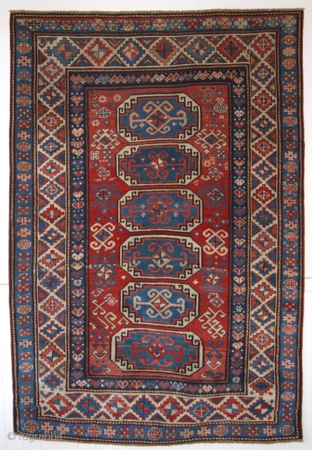 Antique Caucasian Moghan Kazak rug with a vertical row of 6 octagons on a soft red ground.

2nd half 19th century.

Size: 6ft 9in x 4ft 7in (205 x 139cm).

The rug has many small  ...