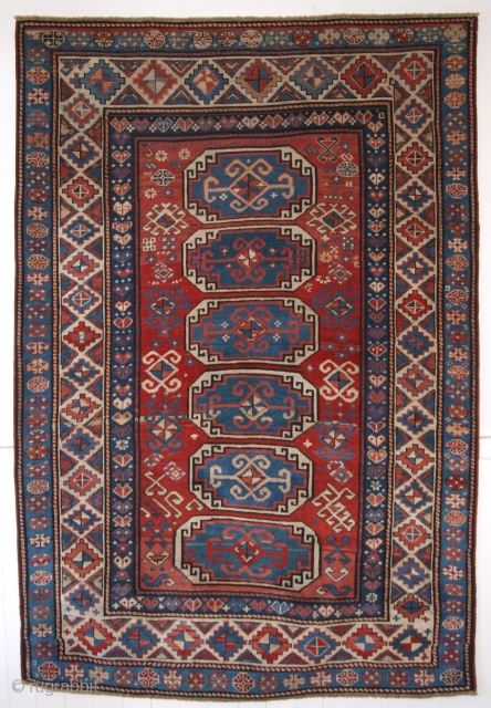 Antique Caucasian Moghan Kazak rug with a vertical row of 6 octagons on a soft red ground.

2nd half 19th century.

Size: 6ft 9in x 4ft 7in (205 x 139cm).

The rug has many small  ...