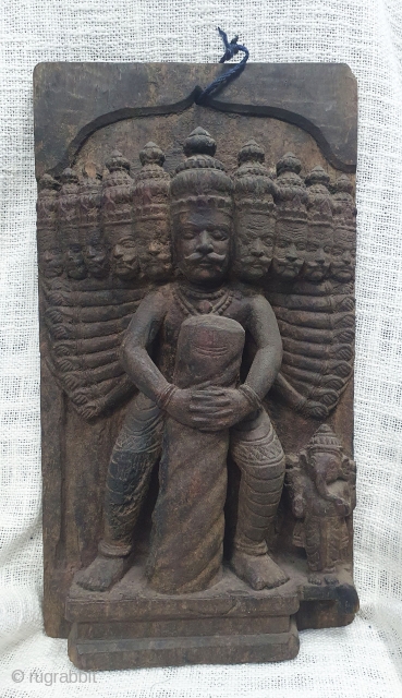 A wooden vintage decorative plaque probably a part of an architectural element showing Ravana holding a Shiva lingam with Ganesha on the side. (It is an episode from the story of Bajinath  ...