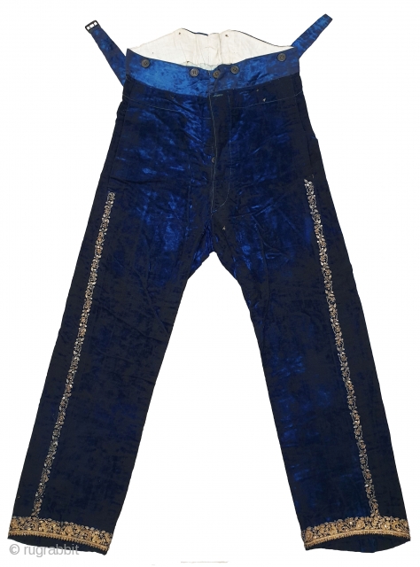 A Pair of velvet trousers in a luxurious blue colour. From Bengal.  India. Late 19th to early 20th century. The back has arrangements for suspenders with buckles made in Germany. The  ...
