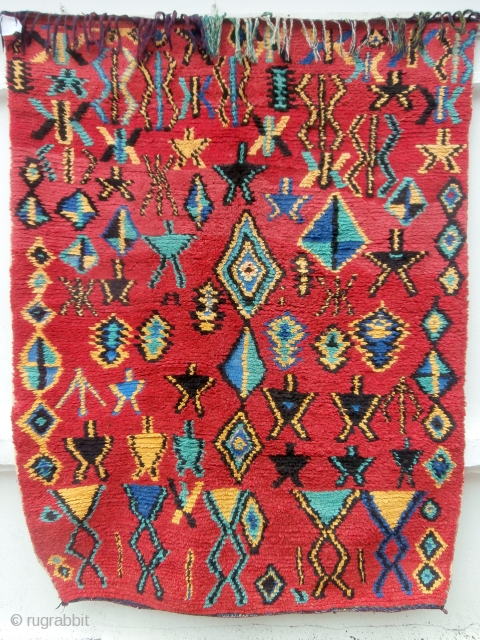 MOROCCAN BERBER HIGH ATLAS RUG A bright, colourful rug with a random scattering of Berber designs and motifs throughout the field. The colours are a deliberate contrast to the endless browns and  ...