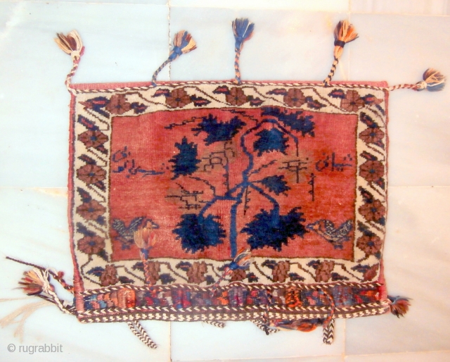 AFSHAR TRIBAL TENT BAG which is rare because of its inscription in the field. The field is dominated by a central tree with songbirds at each lower side. At the top there  ...