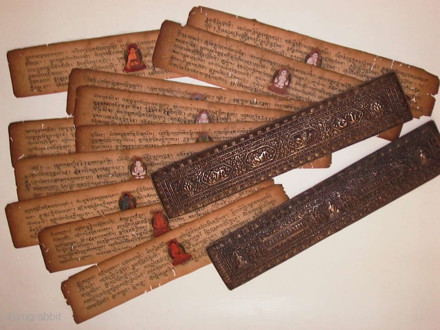 Old Buddhist (Tibetan?) religious book, loose paper pages with text and holy images, metal (silver?) covered wood over and under covers, good condition.          