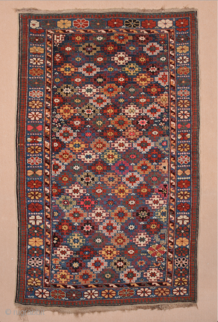 This immaculately drawn chichi displays the extra-wide border section that is typical of the provenance; the narrow midnight blue field contains a repeat of hooked stepped polygons and small octagons, incorporated into  ...