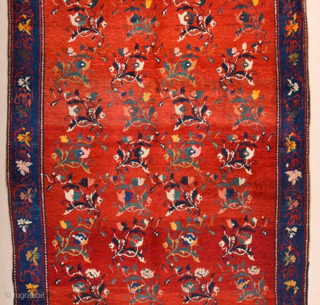 South Caucasian Karabagh Rug. In the Red field, short stems arranged in parallel rows combine into a dense repeat in shades of green, red and pink. Each stem bears a large blossom.  ...