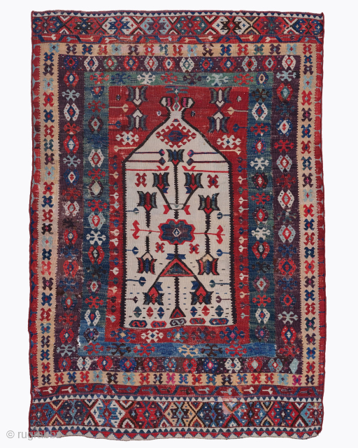 Period: Circa 1800
Origin: West Anatolia
Dimensions: 111 x 164 cm

This rare early 19th century West Anatolian kilim highlights a powerful and rhythmic geometric composition featuring a stark ivory prayer niche or mihrab anchored  ...