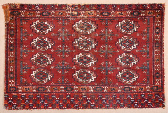 Central Asia West Turkestan Early 19th Century Saryk.This large Saryk Chuval displays twelve primary güls and chemche secondary designs in a dark red field. The main border contains diagonal crosses and hooked  ...