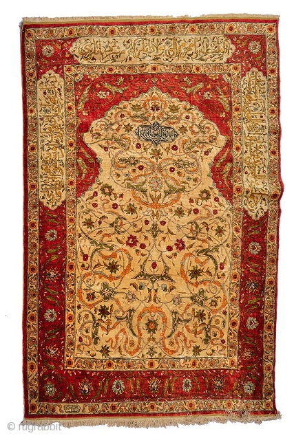 A TURKISH, HEREKE SILK RUG, the central camel ground panel with inscription and scrolling foliate design within a deep red border, further inscribed, 183 x 121cm

To be auctioned on Wednesday 3rd June  ...