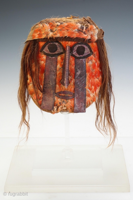 Lot 70. Pre-Columbian Huari South Coast Feather Mummy Face Mask/Head. Woven in natural cotton, the face applied with bright feathers, the eyes with streaming tear motif, long nose and open mouth of  ...