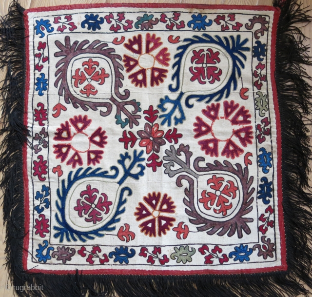 Kyrgyz tribal mirror cover. Silk embroidery on hand loomed cotton. Only light madder embroidery is wool. Size: 55 cm x 53 cm with 7 cm long tassels (22” X 21” x 3”).  ...