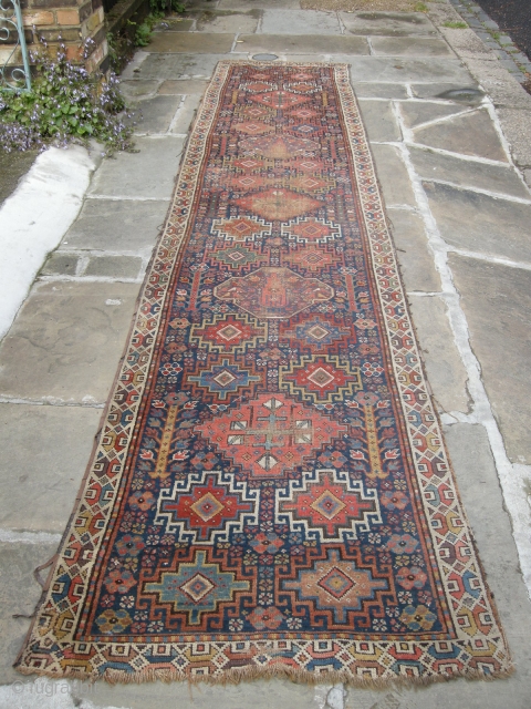 a very beautiful mid or early 19th century nw persian ?kurdish runner. Approx 15ft x 3ft. I think it's missing an outer guard there are condition issues. Low parts two very old  ...