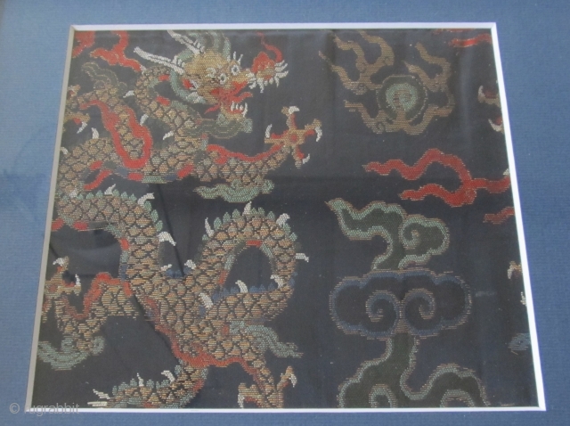 A gold brocaded dragon among clouds chasing the flaming pearl. The fragment is 15cm high and 16,5cm wide. Size of the frame is 25x26cm.
Although the style of the dragon, clouds and colouring  ...