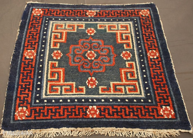 An antique Tibetan mat, 1880-1900

Classic for this type with central floral roundel flamed by key-pattern spandrel. In Buddhist motif and lotus flowerhead border between pearl-seed and plain stripes. This mat has slight  ...