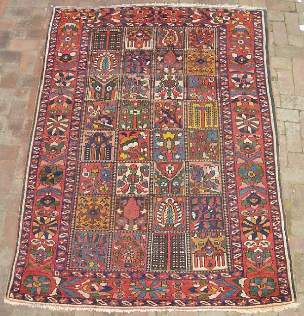 Garden Bahktiari. 5 ft 3 inches x 7 ft 1 inches. Decorative old rug with lots of yellow. Interesting green strip outide the outer boarder. Low but even pile with no foundation  ...