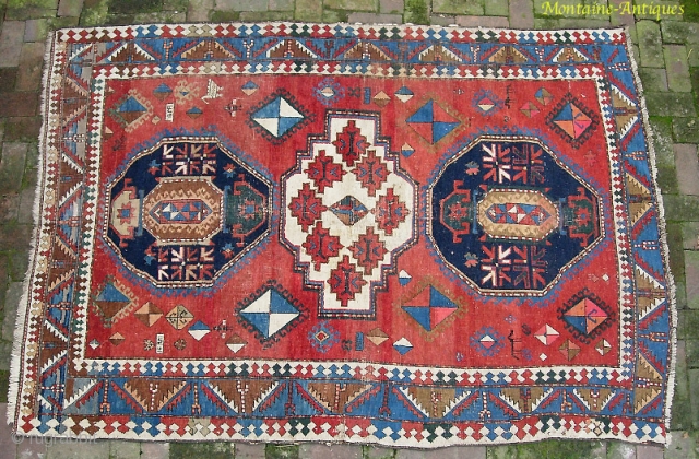 Kazak, 5.3 by 7.7. Circa 19th century.  Possibly Armenian with various inscriptions. There are two hot colors applied sparingly on one side of the rug.  Various old repairs and reweaves.  ...