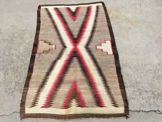 As found: Vintage Navajo rug measuring 3'5"x 5'8" with a stain of unknown substance in one of the ivory blocks in the middle of the rug.  Also a faint discoloration at  ...