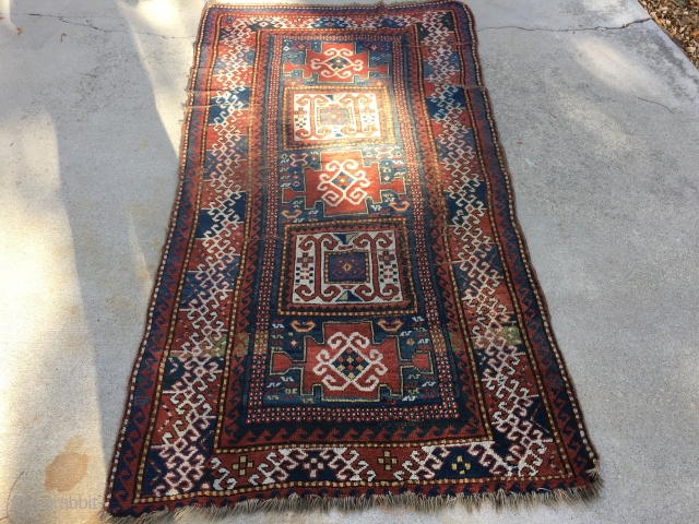 As found: Late 1800's Kazak measuring 3'9" to 4'1" wide by 7'5" long, has foundation showing, has four puckered wear area's, has minor loss of pile at one end, needs attention to  ...