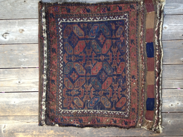 Early Antique Baluch Bag. Complete, with good colors including outstanding blues. Archaic and unusual design. Low pile with some oxidation and some fraying on sides and ends. Nice striped kilim open back.  ...