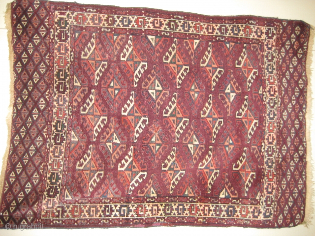 Small Yomud rug, beginning of 20th C. Good,soft pile. Dyrnak guls. Small repair near center, and also two small pink areas in middle of rug edge are repairs. Colors include burgundy background  ...