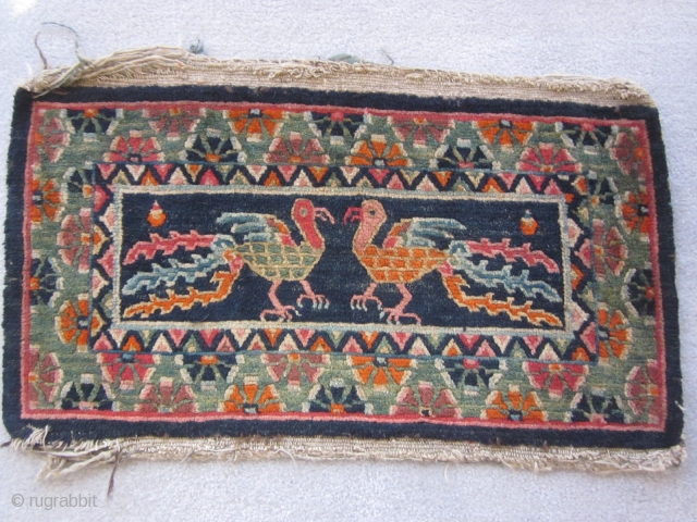 Tibetan table mat, with two facing chicken-like phoenixes, c.1930, 15 by 28 inches.                    